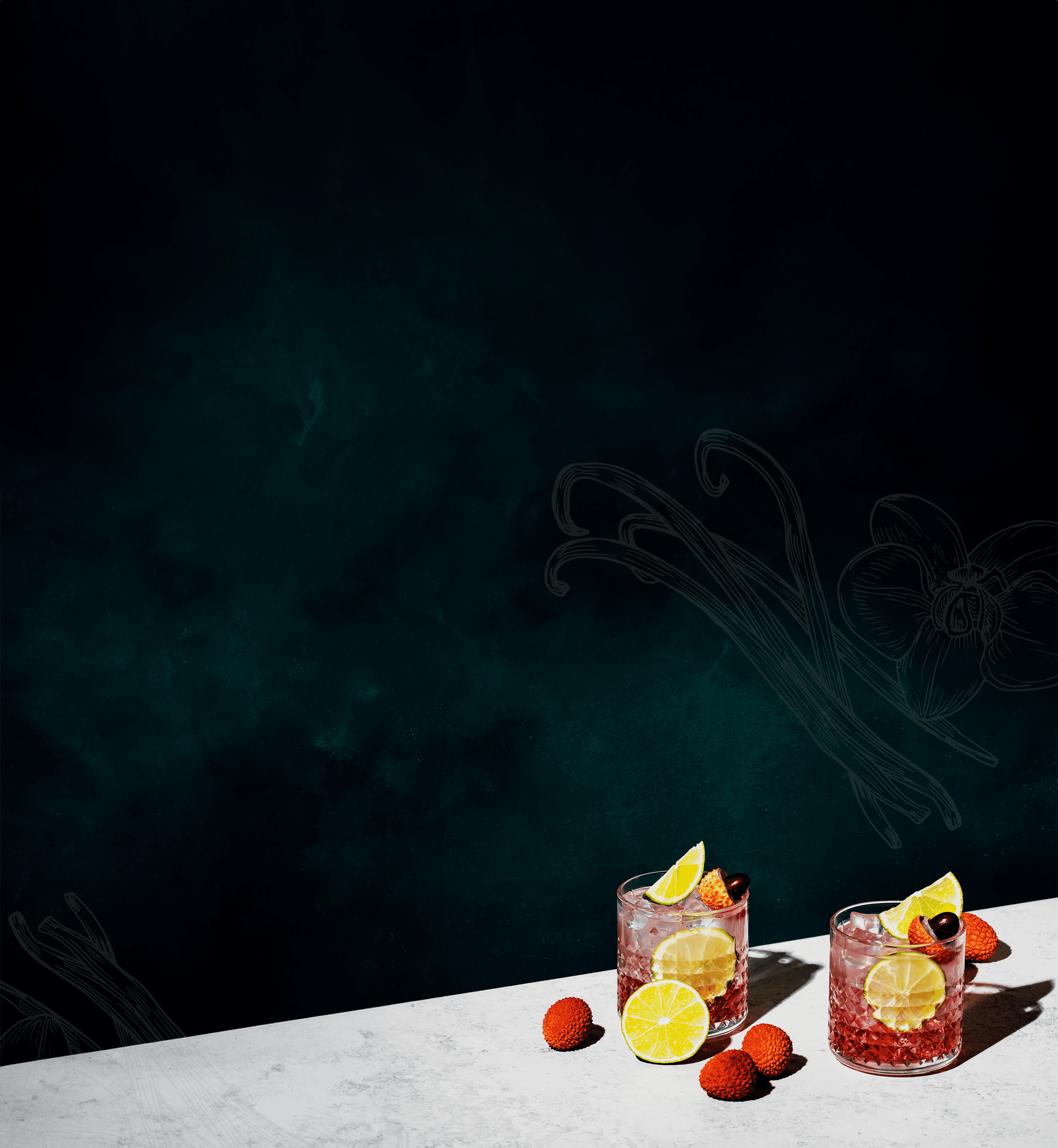 Two cocktail drinks with ice and fruit sitting on a white marble countertop against a dark green background